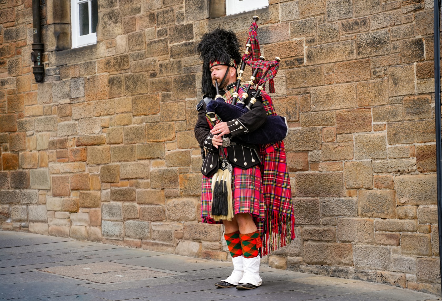 A Scottish piper in full tartan dress