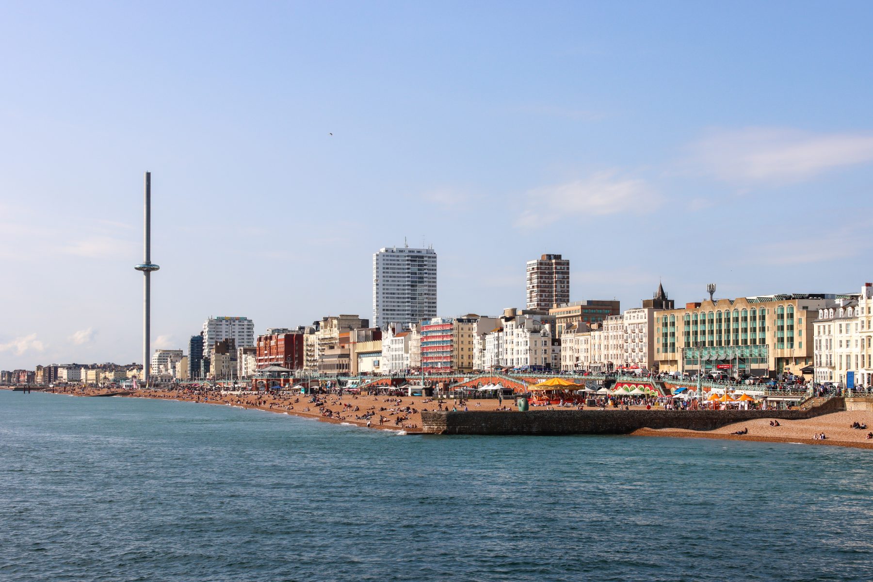 Brighton seafront seen from the sea, with the i360 tower, the beach and Regency buildings along the promenade