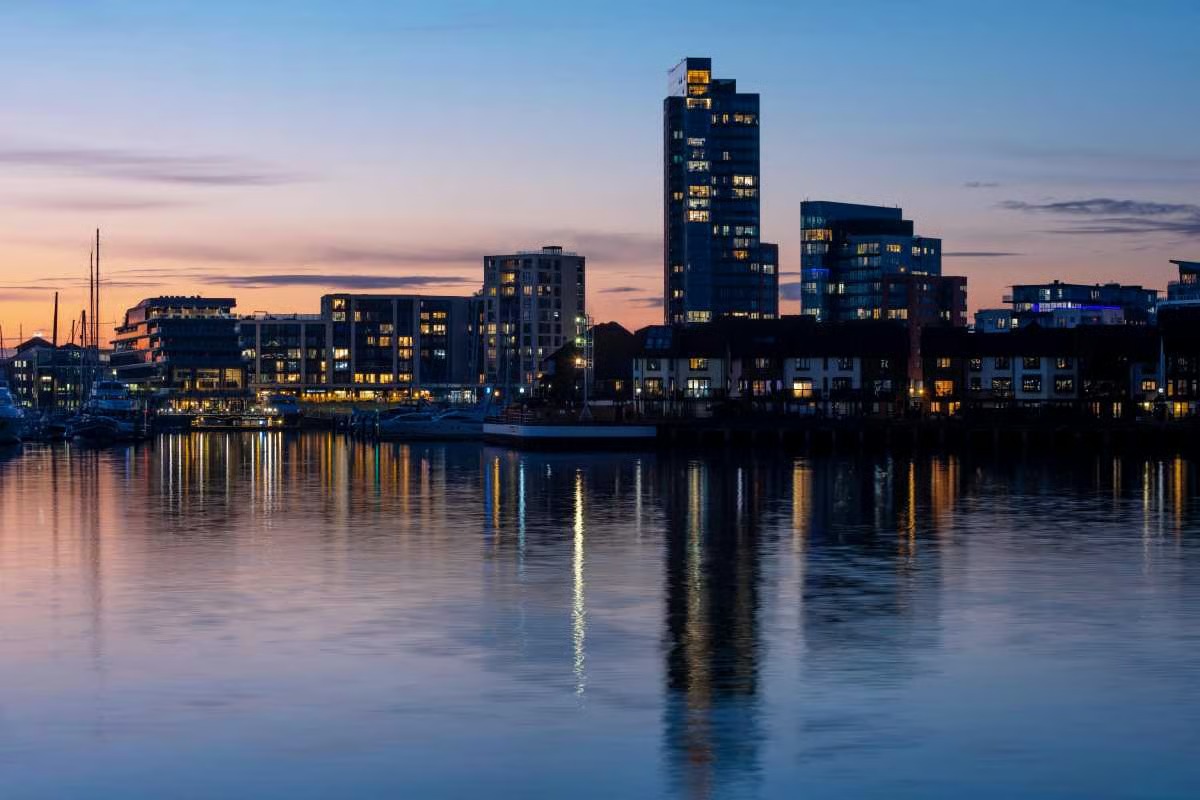 Ocean Village waterfront in Southampton at dusk with lights reflected in the water